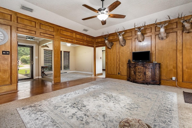 3313 Conlin Dr, Rowlett, TX 75088 - living room featuring ceiling fan, a textured ceiling, and wooden walls