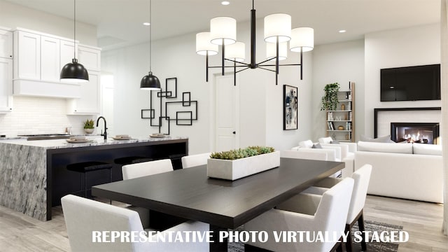 990 Stargrass Dr, Allen, TX 75013 - dining area with light wood-type flooring, recessed lighting, a chandelier, and a glass covered fireplace