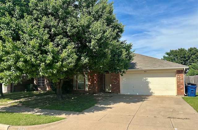 4821 Topaz Ln, Granbury, TX 76049 - obstructed view of property with brick siding, concrete driveway, an attached garage, and a shingled roof