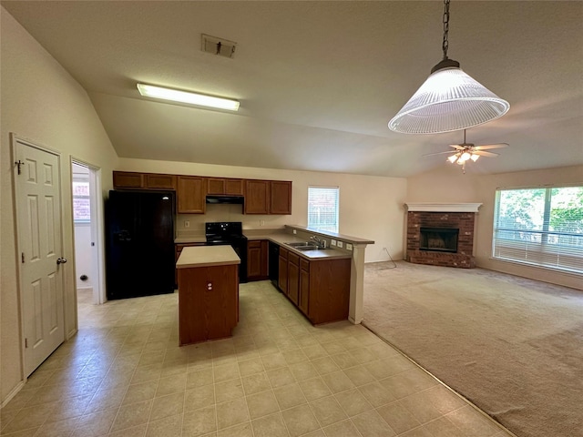 4821 Topaz Ln, Granbury, TX 76049 - kitchen with black appliances, lofted ceiling, under cabinet range hood, a fireplace, and a center island