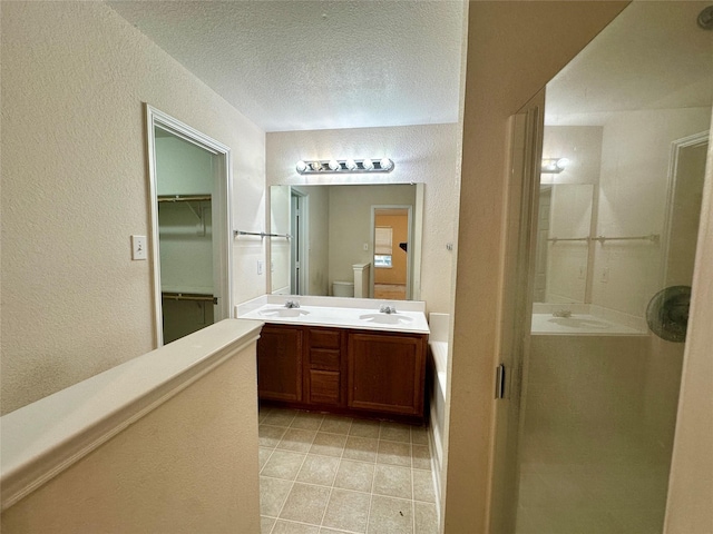 4821 Topaz Ln, Granbury, TX 76049 - bathroom featuring a textured wall, double vanity, a stall shower, tile patterned flooring, and a textured ceiling