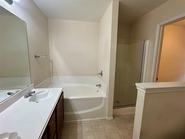 4821 Topaz Ln, Granbury, TX 76049 - bathroom with a bath, vanity, a shower stall, tile patterned floors, and a textured ceiling