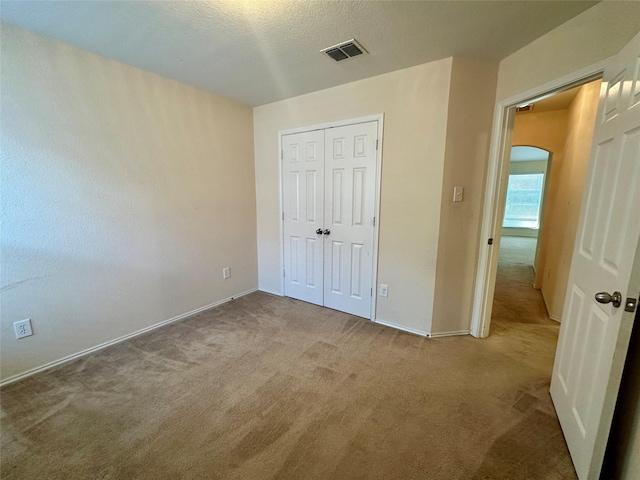 4821 Topaz Ln, Granbury, TX 76049 - unfurnished bedroom with carpet floors, arched walkways, a closet, and baseboards