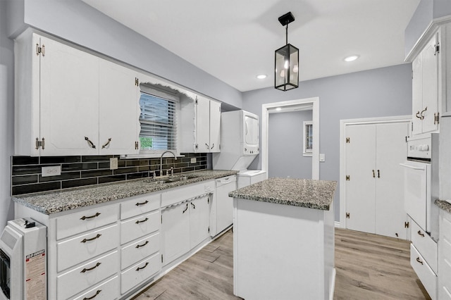 110 W Moore St, Sherman, TX 75090 - kitchen featuring stacked washer / drying machine, a sink, white appliances, a center island, and tasteful backsplash