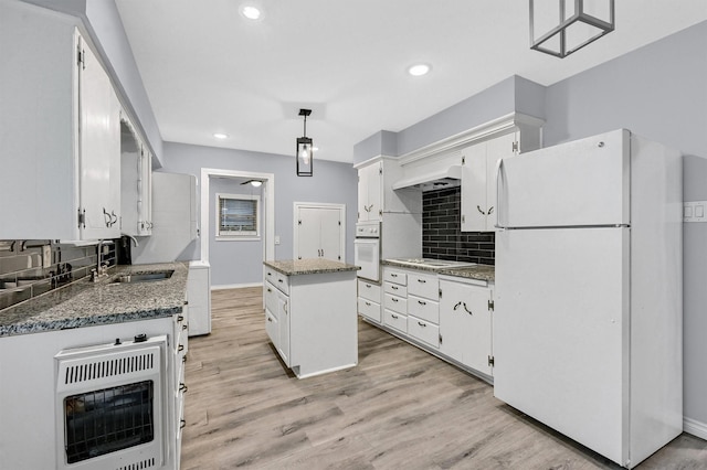 110 W Moore St, Sherman, TX 75090 - kitchen featuring white appliances, a sink, a kitchen island, white cabinetry, and tasteful backsplash