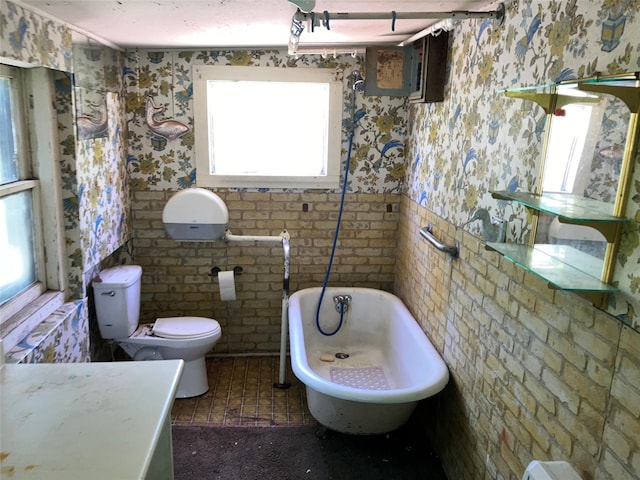 213 18th St, Mineral Wells, TX 76067 - bathroom with a bathtub, toilet, and wallpapered walls