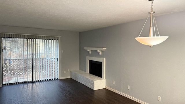4503 N O Connor Rd Unit 1113, Irving, TX 75062 - unfurnished living room featuring healthy amount of natural light, wood finished floors, baseboards, a fireplace, and a textured ceiling