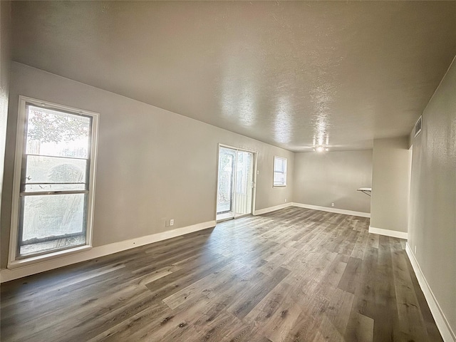 980 S Weatherred Dr Unit A, Richardson, TX 75080 - spare room featuring dark wood finished floors, baseboards, and a textured ceiling
