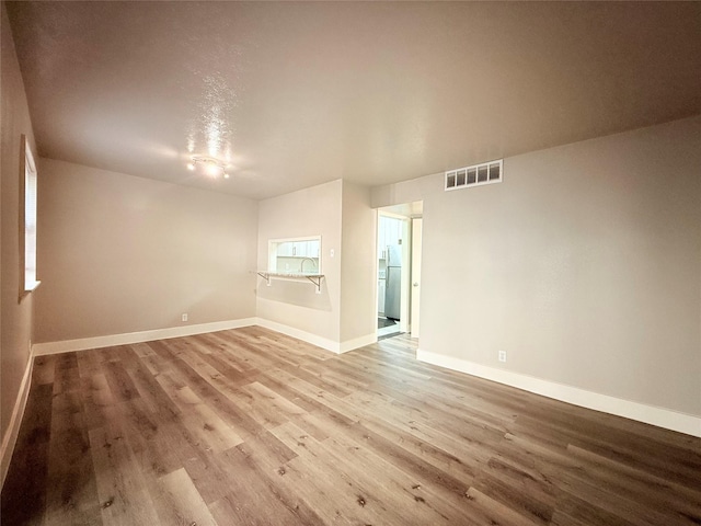 980 S Weatherred Dr Unit A, Richardson, TX 75080 - empty room featuring wood finished floors and baseboards