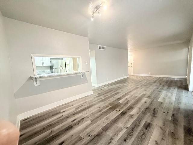 980 S Weatherred Dr Unit A, Richardson, TX 75080 - unfurnished living room with wood finished floors and baseboards