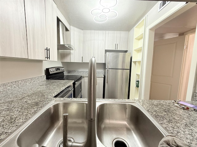 980 S Weatherred Dr Unit A, Richardson, TX 75080 - kitchen featuring appliances with stainless steel finishes, wall chimney exhaust hood, light stone countertops, a textured ceiling, and modern cabinets