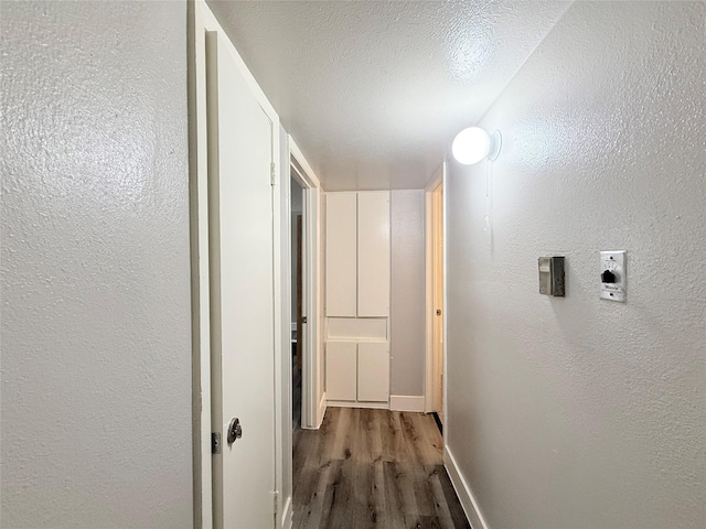 980 S Weatherred Dr Unit A, Richardson, TX 75080 - corridor featuring wood finished floors, a textured wall, and baseboards