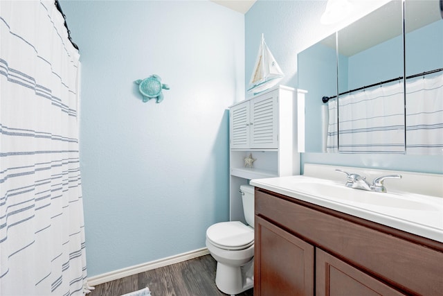 306 Breaux Ln, Mabank, TX 75147 - bathroom with wood finished floors, toilet, vanity, baseboards, and curtained shower
