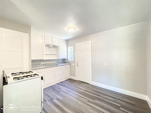 2234 Meander St, Abilene, TX 79602 - kitchen with white gas range, a sink, baseboards, dark wood finished floors, and white cabinets
