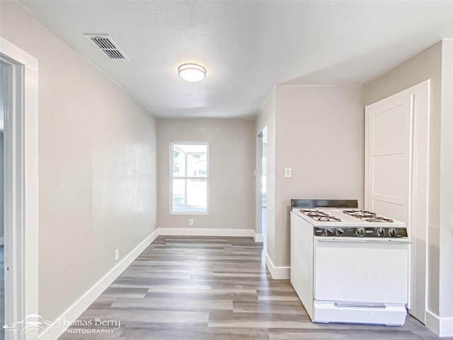 2234 Meander St, Abilene, TX 79602 - kitchen featuring white gas stove, wood finished floors, baseboards, and a textured ceiling