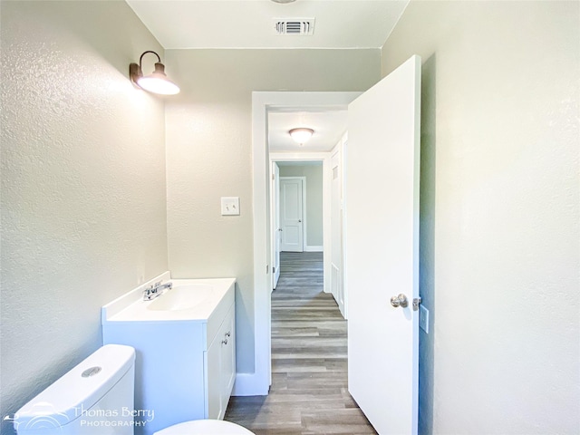 2234 Meander St, Abilene, TX 79602 - half bath featuring toilet, wood finished floors, vanity, and baseboards