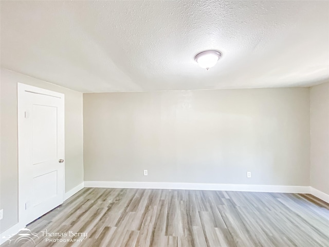 2234 Meander St, Abilene, TX 79602 - empty room with light wood-type flooring, a textured ceiling, and baseboards