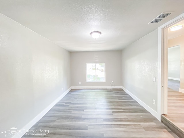 2234 Meander St, Abilene, TX 79602 - empty room featuring wood finished floors, baseboards, and a textured ceiling