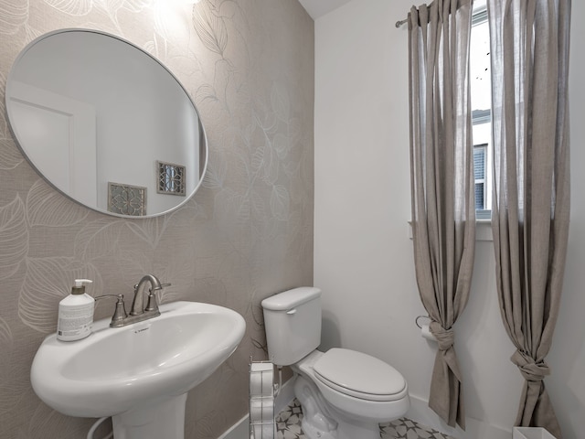 1409 Silver Marten Trl, Arlington, TX 76005 - half bath with a sink, healthy amount of natural light, baseboards, and toilet