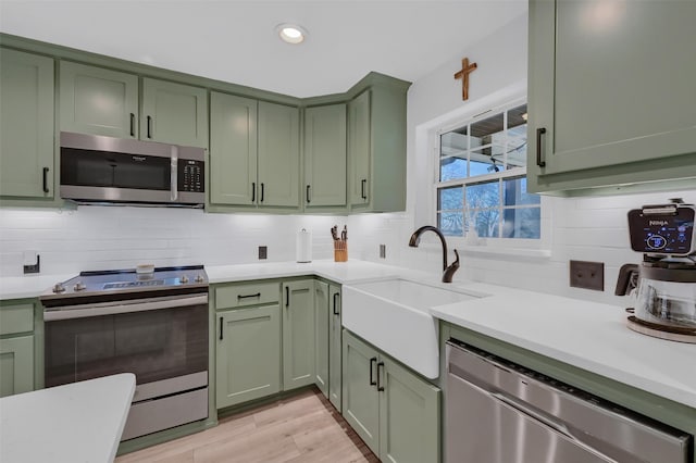 4491 Dugan Chapel Rd, Bells, TX 75414 - kitchen with green cabinets, stainless steel appliances, a sink, light countertops, and decorative backsplash