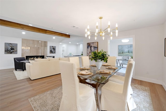 2520 Delmar Dr, Plano, TX 75075 - dining area featuring a chandelier, light wood-style flooring, beamed ceiling, recessed lighting, and a tile fireplace