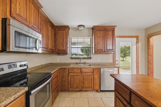 2790 Fairview Rd, Millsap, TX 76066 - kitchen featuring appliances with stainless steel finishes, a sink, plenty of natural light, and brown cabinets