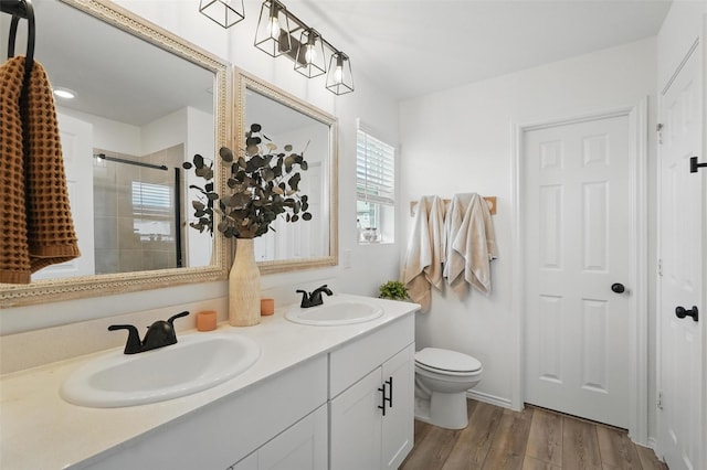 1943 Applewood Trl, Forney, TX 75126 - bathroom featuring a tile shower, double vanity, wood finished floors, and toilet