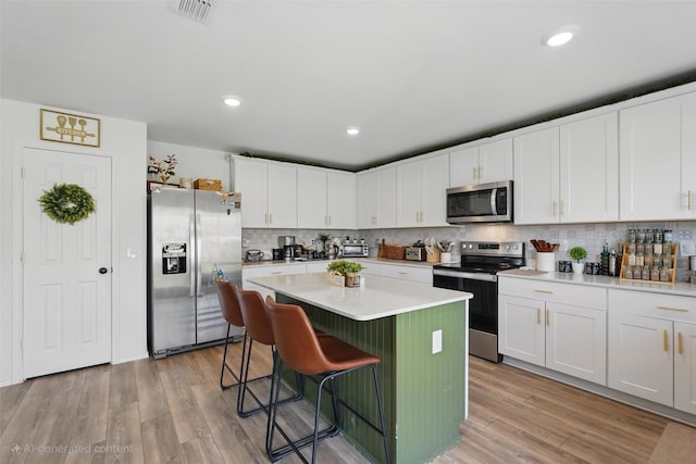 1943 Applewood Trl, Forney, TX 75126 - kitchen with stainless steel appliances, a kitchen island, white cabinets, a kitchen breakfast bar, and tasteful backsplash