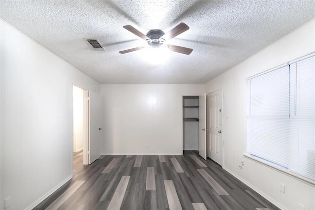 1030 Tyler St, Cooper, TX 75432 - empty room with dark wood-type flooring, ceiling fan, a textured ceiling, and baseboards