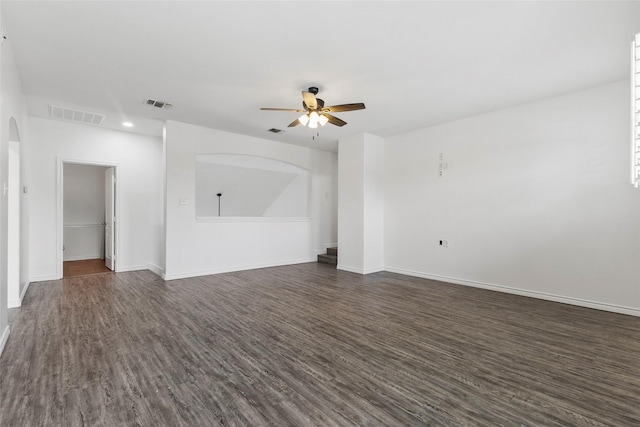 230 Sweetheart Ln, Longview, TX 75605 - unfurnished living room with arched walkways, dark wood-style flooring, a ceiling fan, baseboards, and recessed lighting