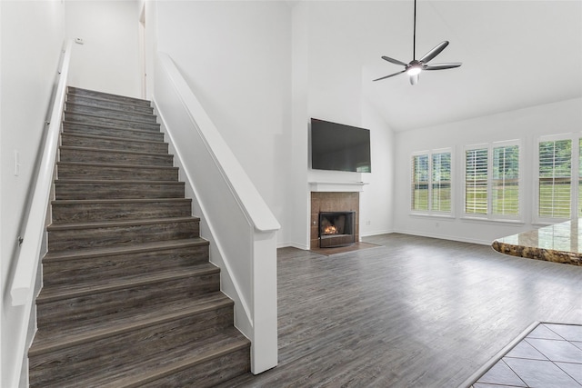 230 Sweetheart Ln, Longview, TX 75605 - stairway with high vaulted ceiling, a tile fireplace, a ceiling fan, wood finished floors, and baseboards