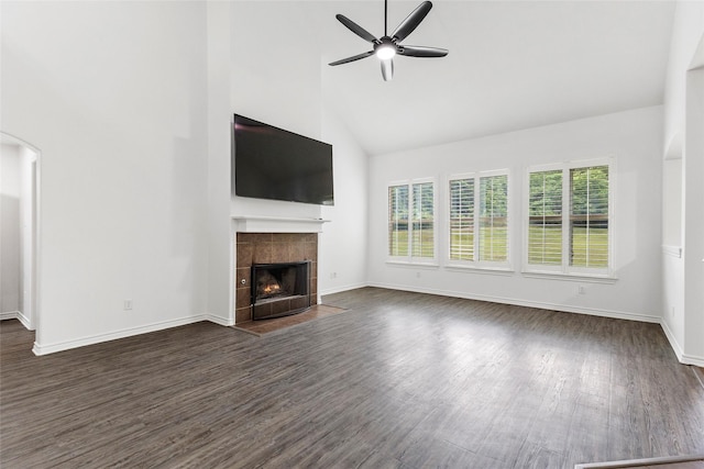 230 Sweetheart Ln, Longview, TX 75605 - unfurnished living room featuring plenty of natural light, high vaulted ceiling, a ceiling fan, a tiled fireplace, and dark wood finished floors