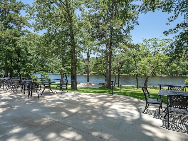 136 Lariat Loop, Holly Lake Ranch, TX 75765 - view of home's community with outdoor dining space, a patio, a water view, and a yard
