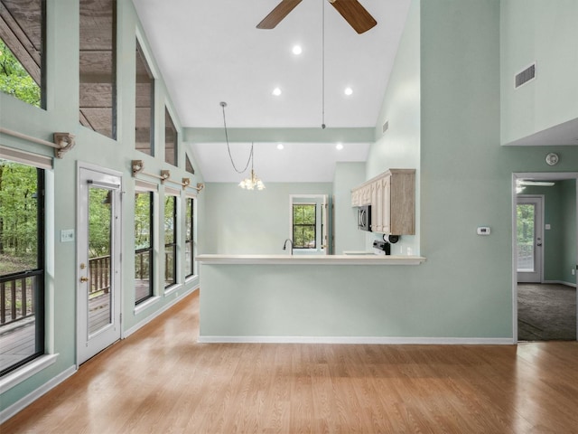 136 Lariat Loop, Holly Lake Ranch, TX 75765 - unfurnished living room featuring high vaulted ceiling, light wood-type flooring, a ceiling fan, a chandelier, and baseboards