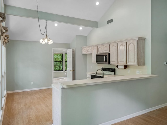 136 Lariat Loop, Holly Lake Ranch, TX 75765 - kitchen featuring stainless steel microwave, light countertops, stove, a chandelier, and a peninsula