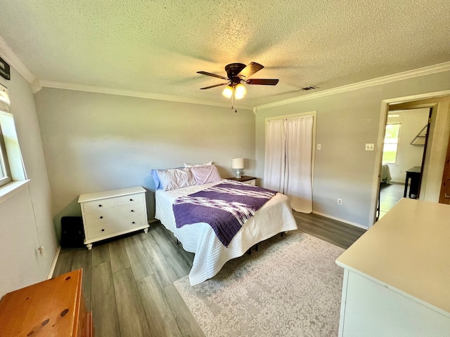 3377 W Moonlight Dr, Robinson, TX 76706 - bedroom featuring wood finished floors, crown molding, a textured ceiling, a ceiling fan, and a closet