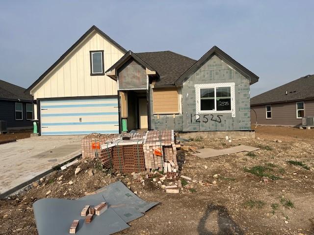 12525 Tarres Ct, Lorena, TX 76655 - view of front of property featuring board and batten siding, driveway, a garage, and stone siding
