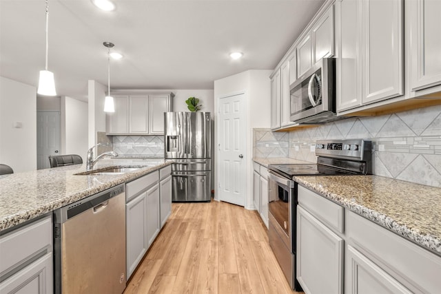745 Brockwell Bnd, Forney, TX 75126 - kitchen with appliances with stainless steel finishes, a sink, backsplash, light wood-type flooring, and light stone counters