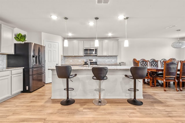 745 Brockwell Bnd, Forney, TX 75126 - kitchen with stainless steel appliances, backsplash, a kitchen bar, and recessed lighting
