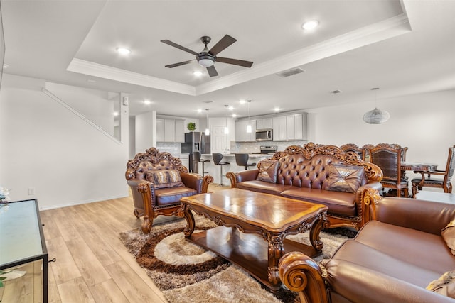 745 Brockwell Bnd, Forney, TX 75126 - living room featuring a tray ceiling, light wood-style floors, a ceiling fan, ornamental molding, and recessed lighting