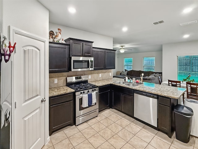 6920 Cruiser Ln, Fort Worth, TX 76179 - kitchen featuring stainless steel appliances, a sink, ceiling fan, light tile patterned floors, and tasteful backsplash