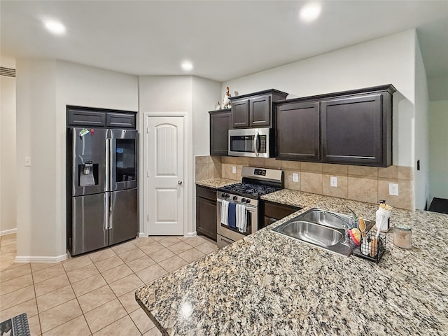 6920 Cruiser Ln, Fort Worth, TX 76179 - kitchen featuring appliances with stainless steel finishes, light tile patterned floors, a sink, tasteful backsplash, and baseboards