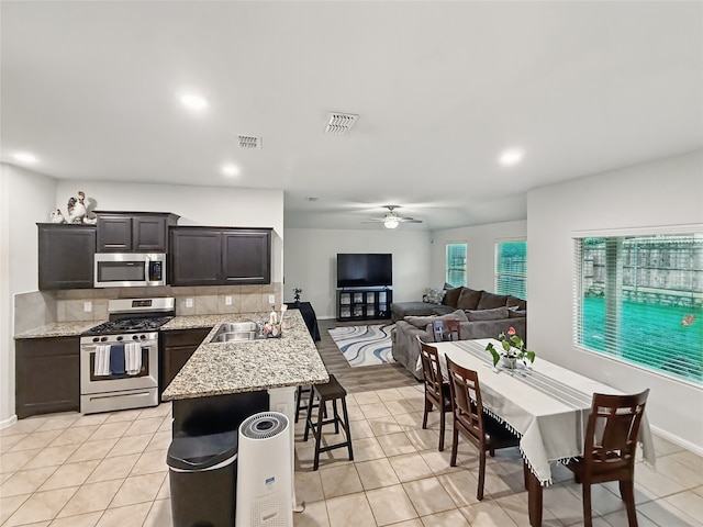 6920 Cruiser Ln, Fort Worth, TX 76179 - kitchen with appliances with stainless steel finishes, a breakfast bar, ceiling fan, open floor plan, and a sink