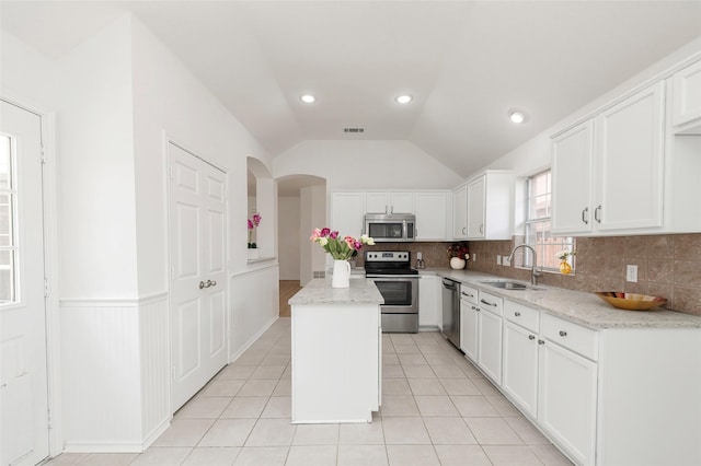 3072 Bigleaf Dr, Little Elm, TX 75068 - kitchen with stainless steel appliances, a sink, decorative backsplash, a kitchen island, and white cabinetry
