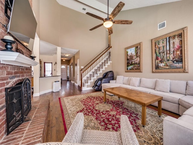 3968 Valez Dr, Carrollton, TX 75007 - living area with dark wood-style flooring, a ceiling fan, baseboards, a fireplace, and stairway