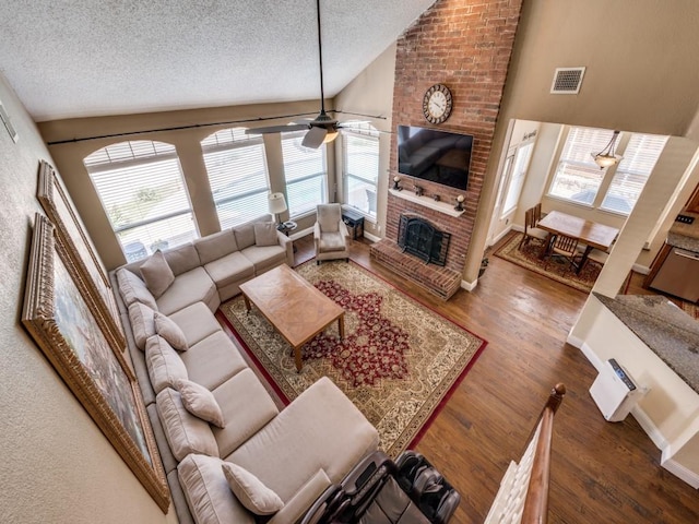 3968 Valez Dr, Carrollton, TX 75007 - living room with a ceiling fan, a textured ceiling, a fireplace, wood finished floors, and high vaulted ceiling