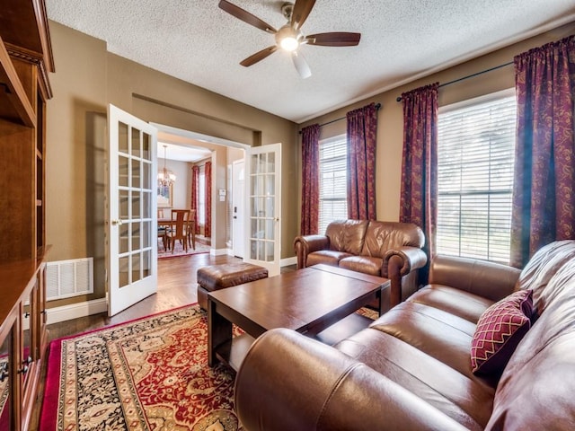 3968 Valez Dr, Carrollton, TX 75007 - living area featuring french doors, a textured ceiling, a ceiling fan, a chandelier, and baseboards