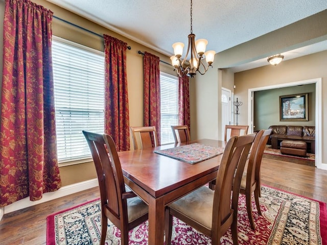 3968 Valez Dr, Carrollton, TX 75007 - dining room with a chandelier, wood finished floors, a textured ceiling, and baseboards