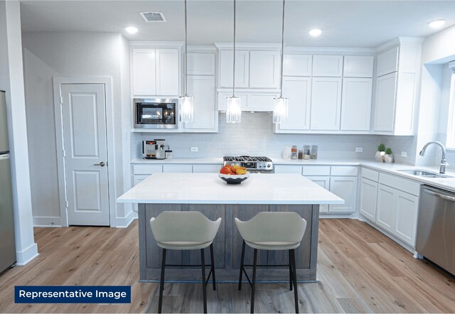5212 Deep Creek Dr, Fort Worth, TX 76179 - kitchen with a sink, stainless steel appliances, white cabinets, tasteful backsplash, and recessed lighting