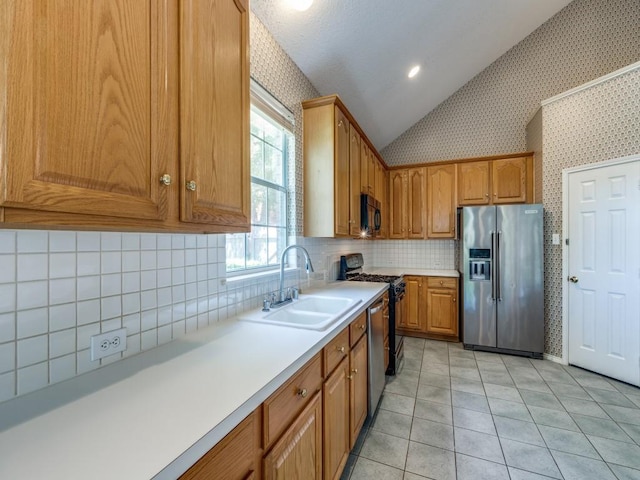 2614 Tourette Ct, Mckinney, TX 75070 - kitchen with appliances with stainless steel finishes, wallpapered walls, lofted ceiling, a sink, and light countertops